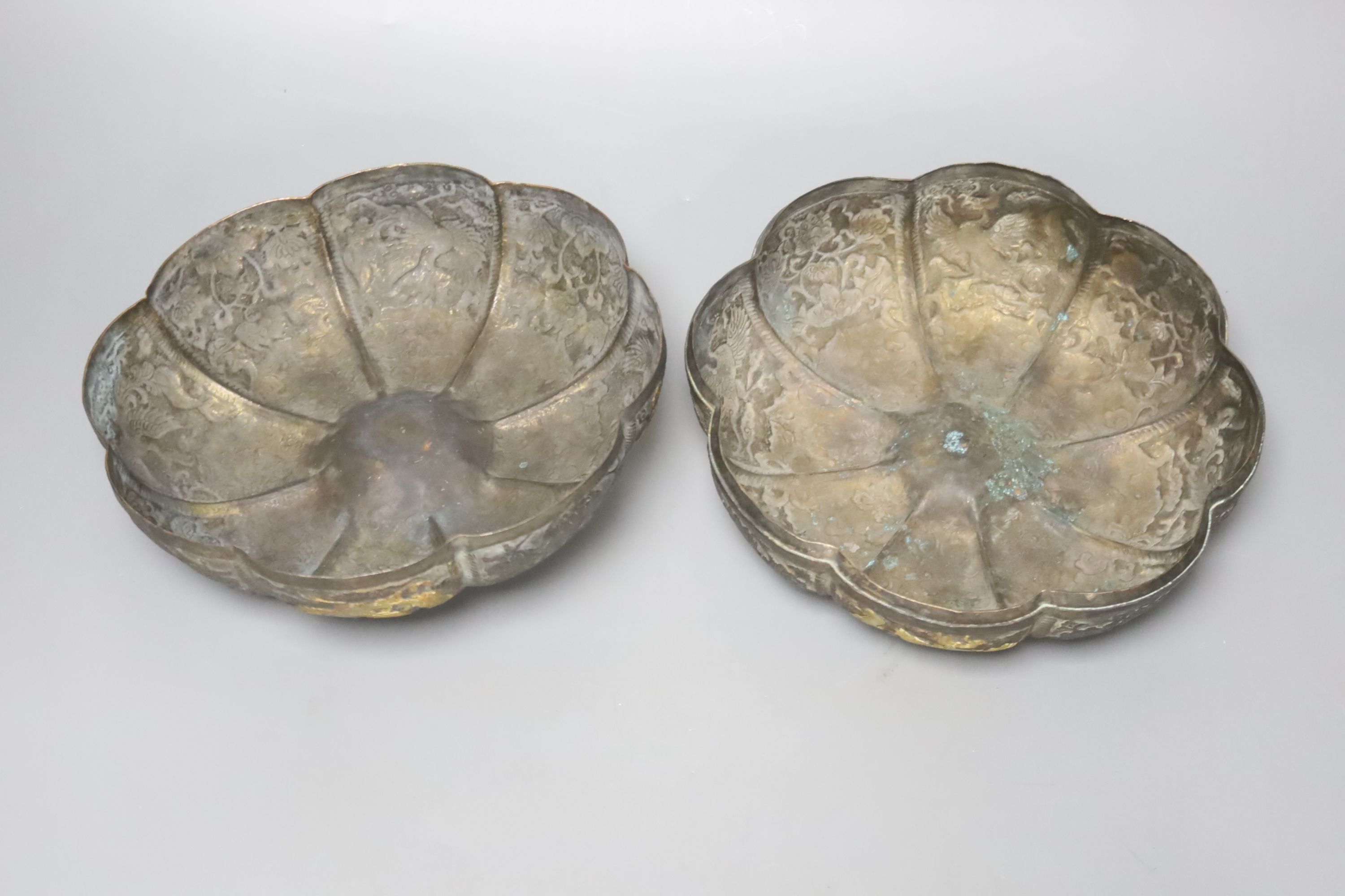 A 19th century Chinese melon-shaped silvered bronze box and cover, applied with gold figures of dragons in flight, Tang dynasty or later, 19cm diameter 10cm high
